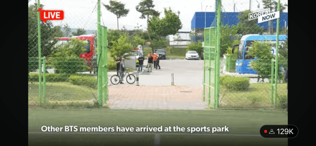 screencap of the entrance to the sports park where fans and news crews awaited the discharge of BTS members RM and V