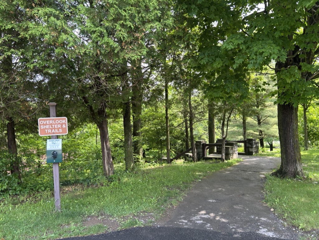 A trail through the trees with a sign to Overlook Shelter and Trais