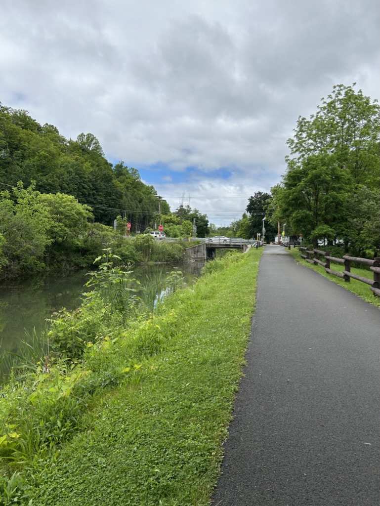 A paved hiking trail stretches alongside a canal