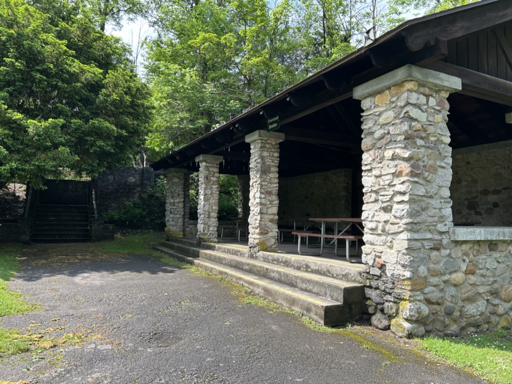 A stone brick shelter with picnic tables inside