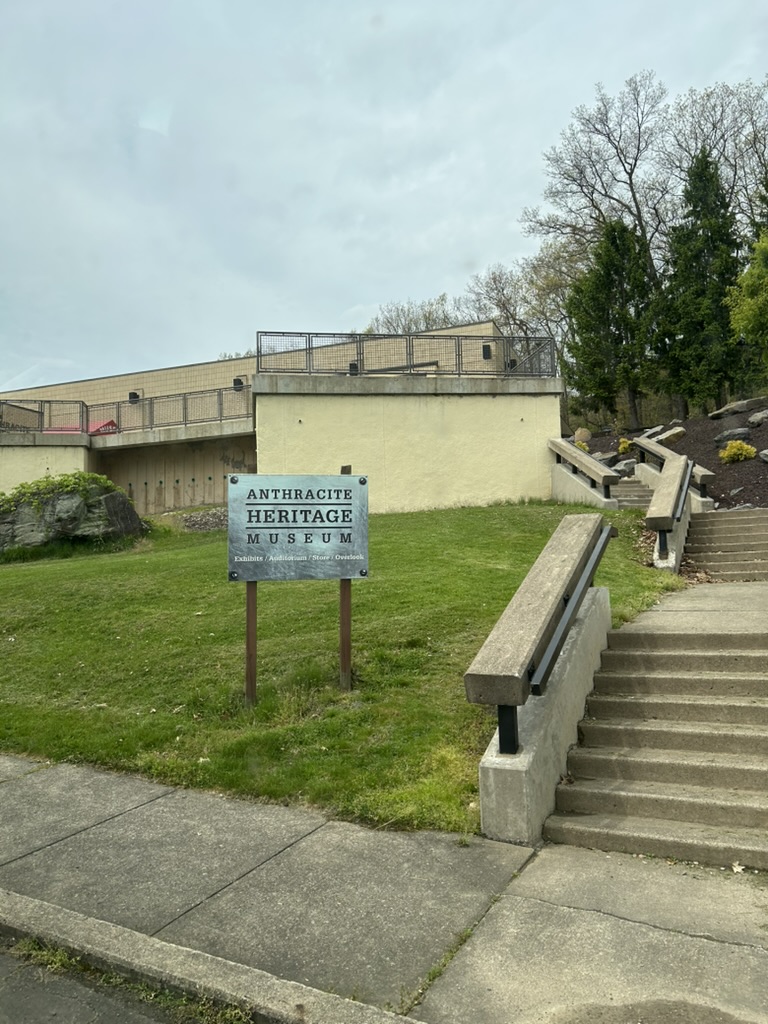 Entry to the Anthracite Heritage Museum. A stone stairway in three sections leads up to the fenced-in plaza in front of the museum.