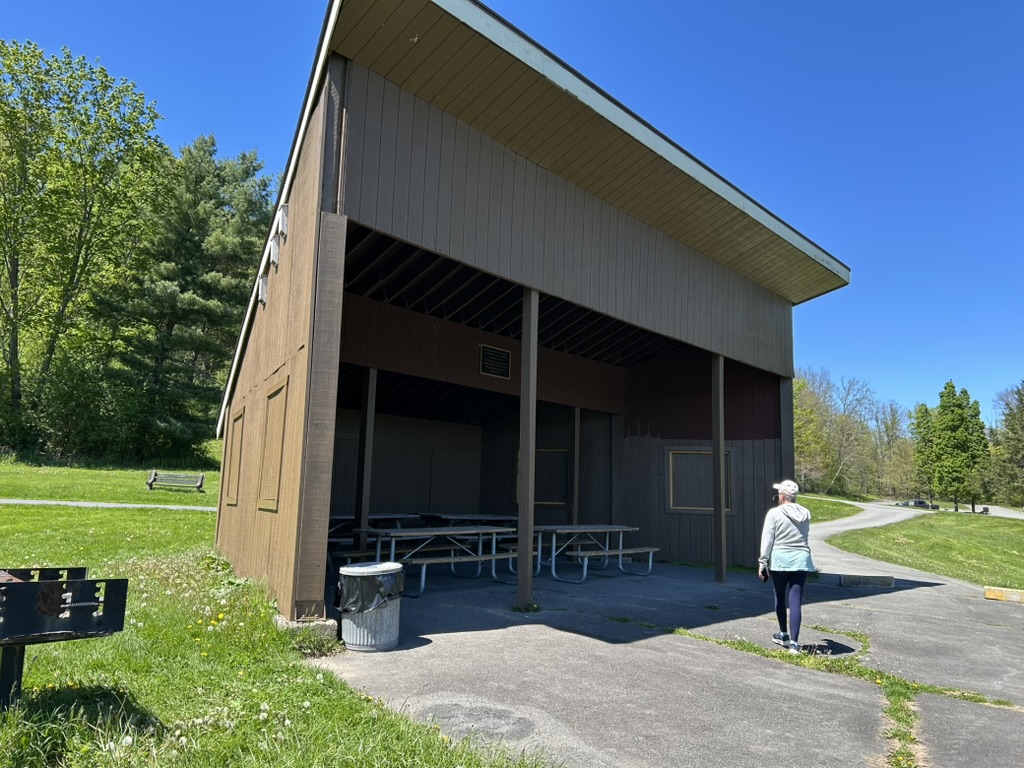 The warming hut is a large building enclosed on three sides with picnic tables inside