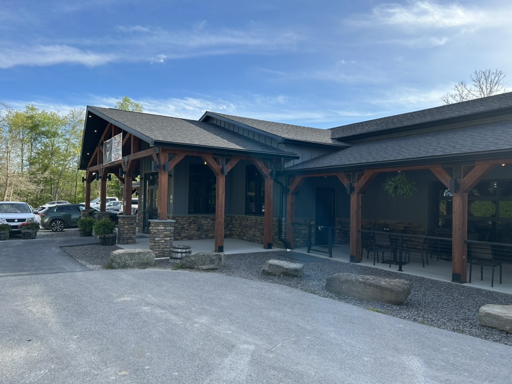 A one-story restaurant building with front entrance patio and side patios with tables