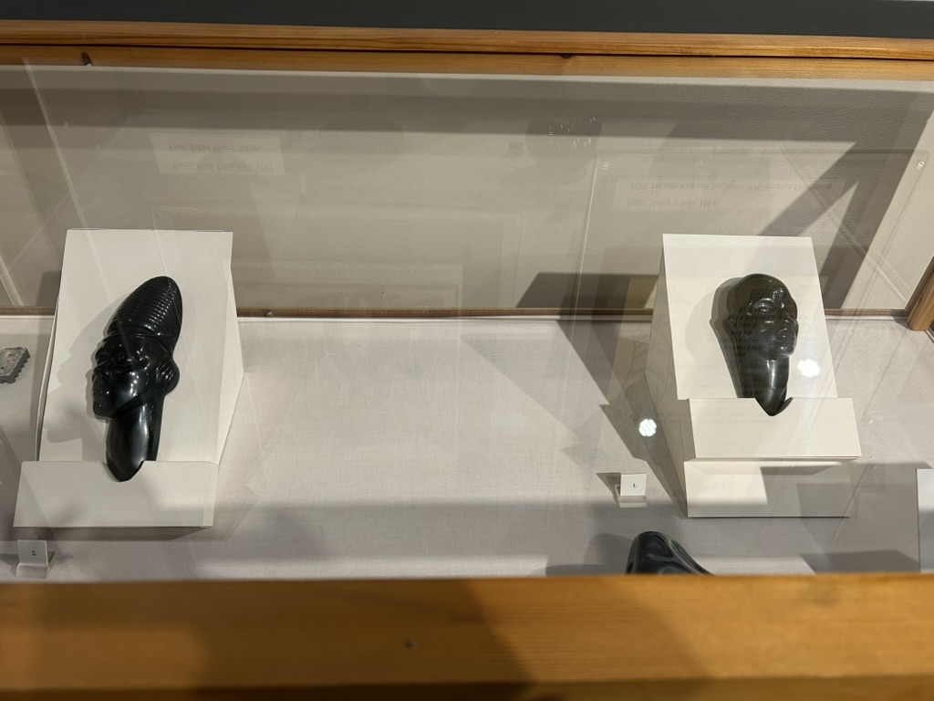 Two small busts carved from anthracite coal in a display case